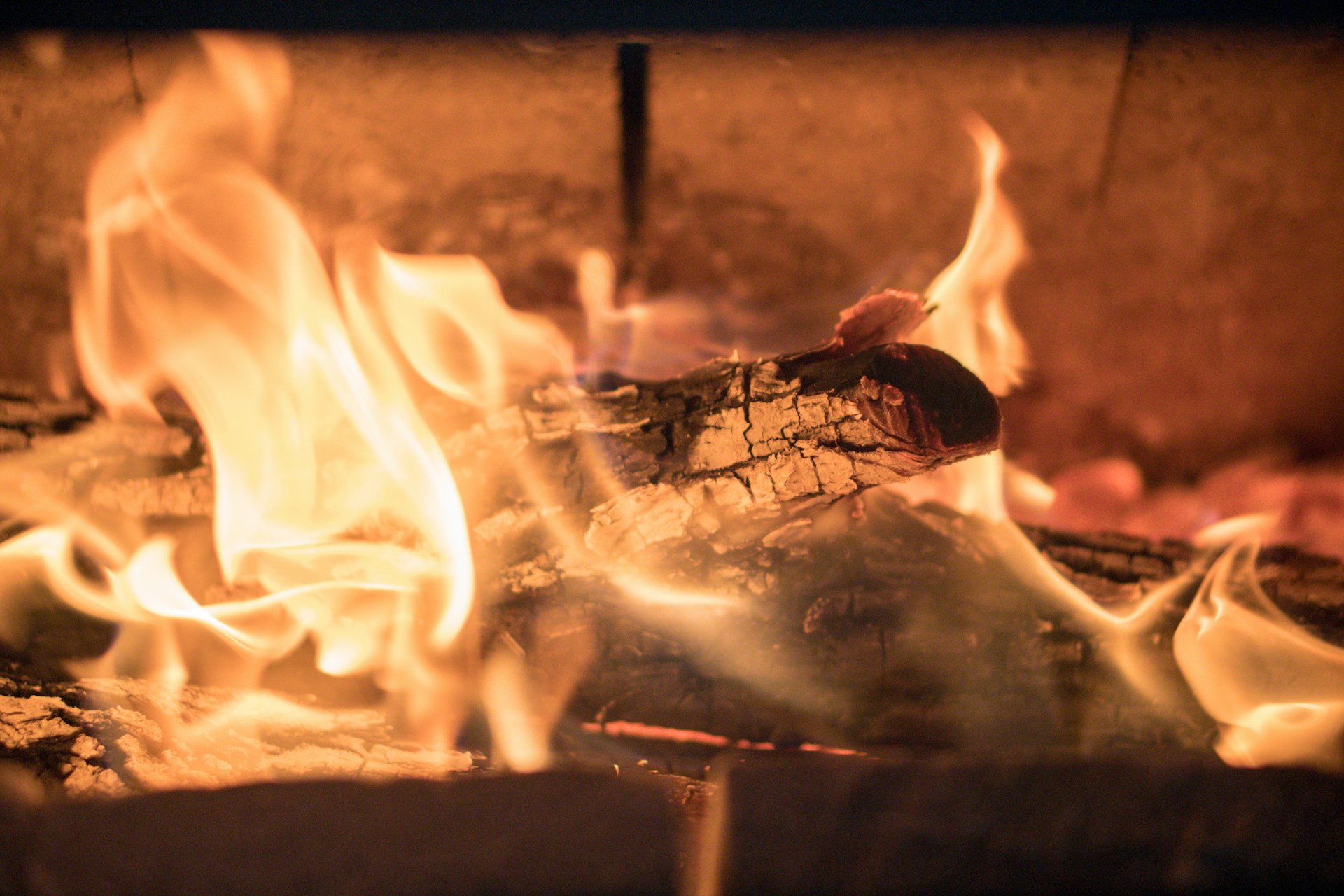 Logs burning inside a wood-burning stove.