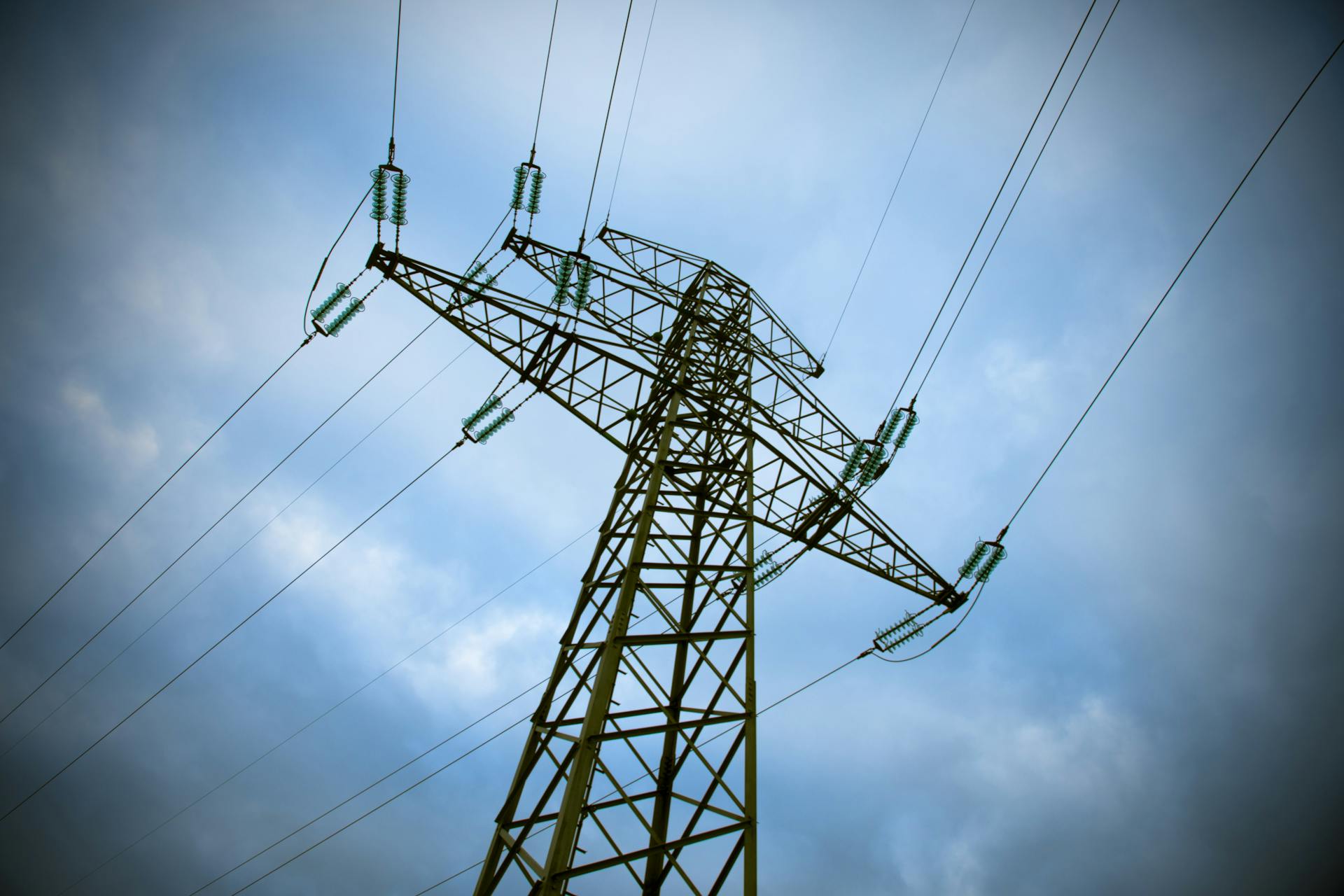 Transmission wires against a blue background with some clouds